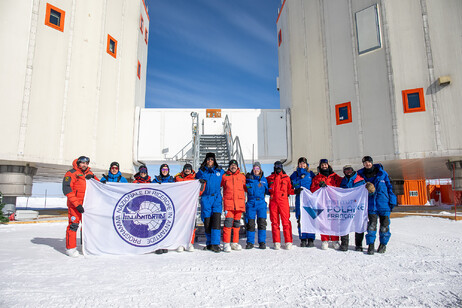 I 13 ricercatori e tecnici della campgna di ricerca invernale, alle loro spalle le due torri della base Concordia (fonte: ENEA)