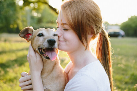 Una adolescente coccola il suo piccolo cane meticcio foto iStock.