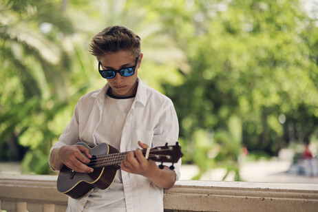 Un adolescente suona l'ukulele foto iStock.